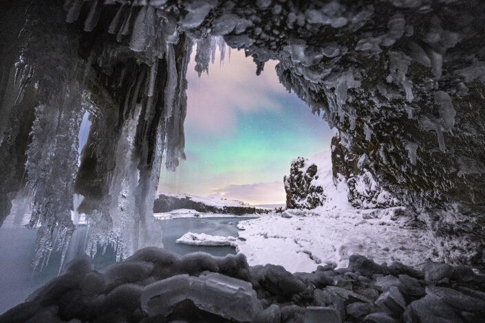 Photo of the northern lights seen from an ice cave in Iceland. Buy a canvas, framed or acrylic fine art print.