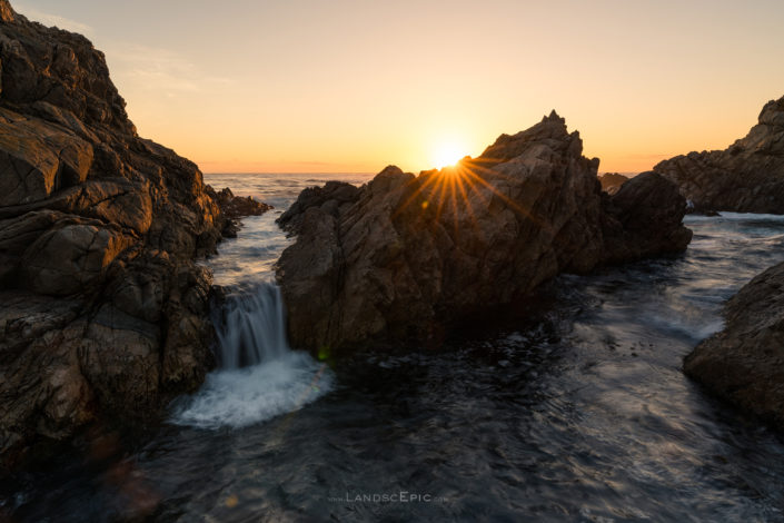 Photo of a small waterfall created by waves passing through rocks at Garrapata National Park, California.nBuy a canvas, framed or acrylic fine art print.