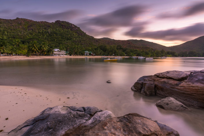 Photo of a sunset at a beach on Grand Anse island in Seychelles. Buy a canvas, framed or acrylic fine art print.