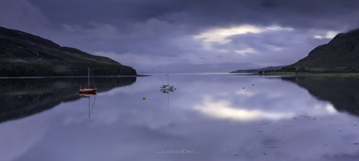 Serene scene at a lake with two boats on Isle of Sky in Scotland. Buy a canvas, framed or acrylic fine art print.