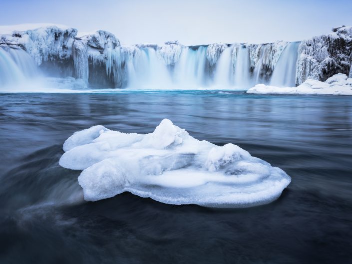 Long exposure photography of the frozen Godafoss (Waterfall of Gods) in the North of Iceland. Buy a canvas, framed or acrylic fine art print.